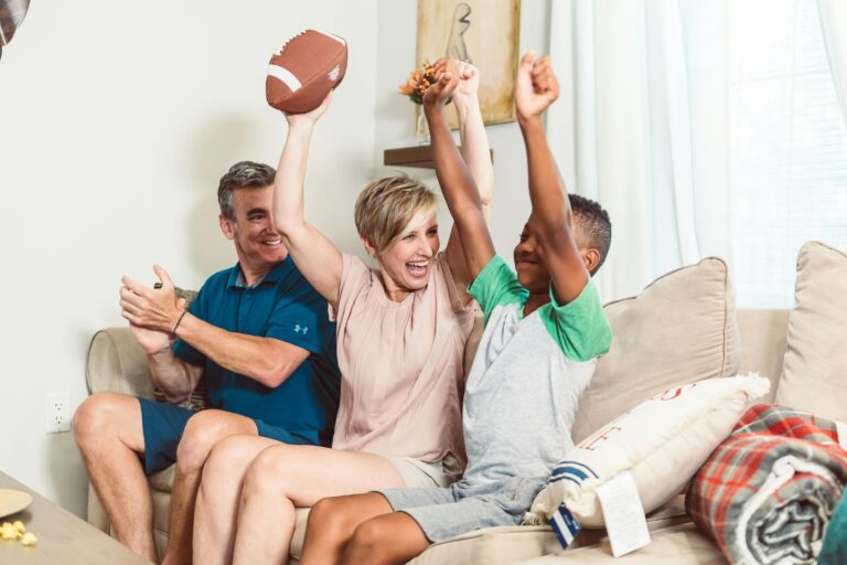 Happy family enjoying togetherness and fun indoors, celebrating with a football.