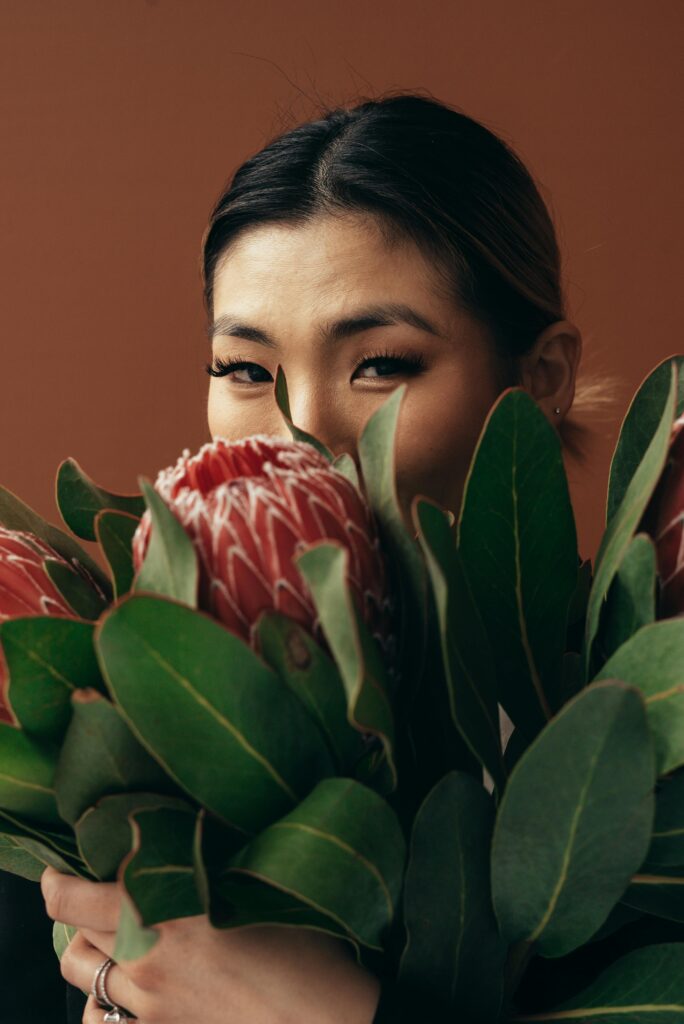 A woman holding protea flowers, creating a serene and natural atmosphere.